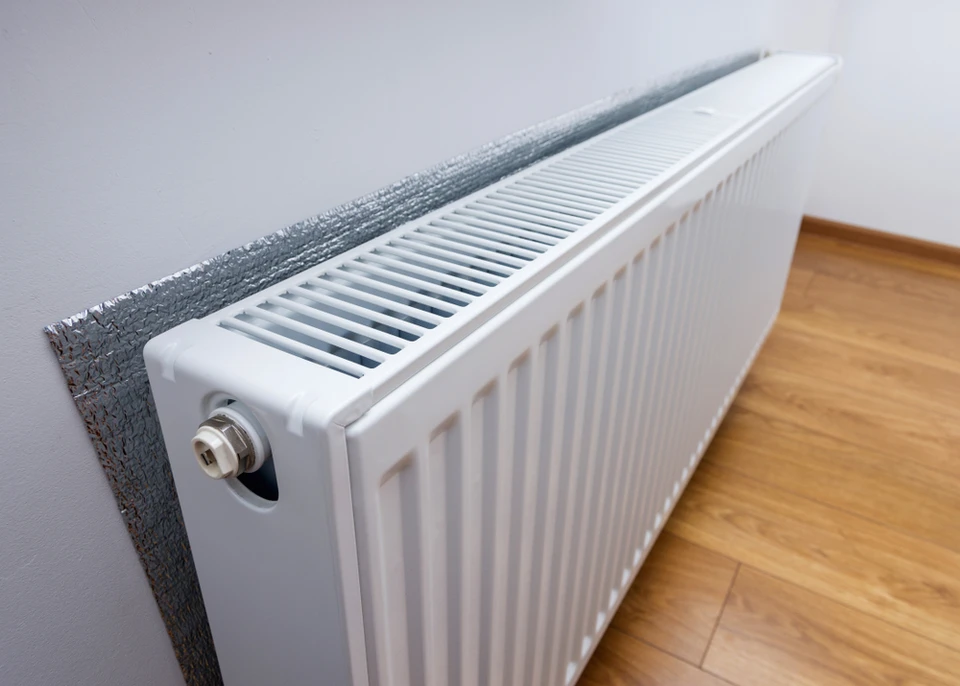 Intérieur résidentiel avec radiateur à eau chaude installé le long d'un mur