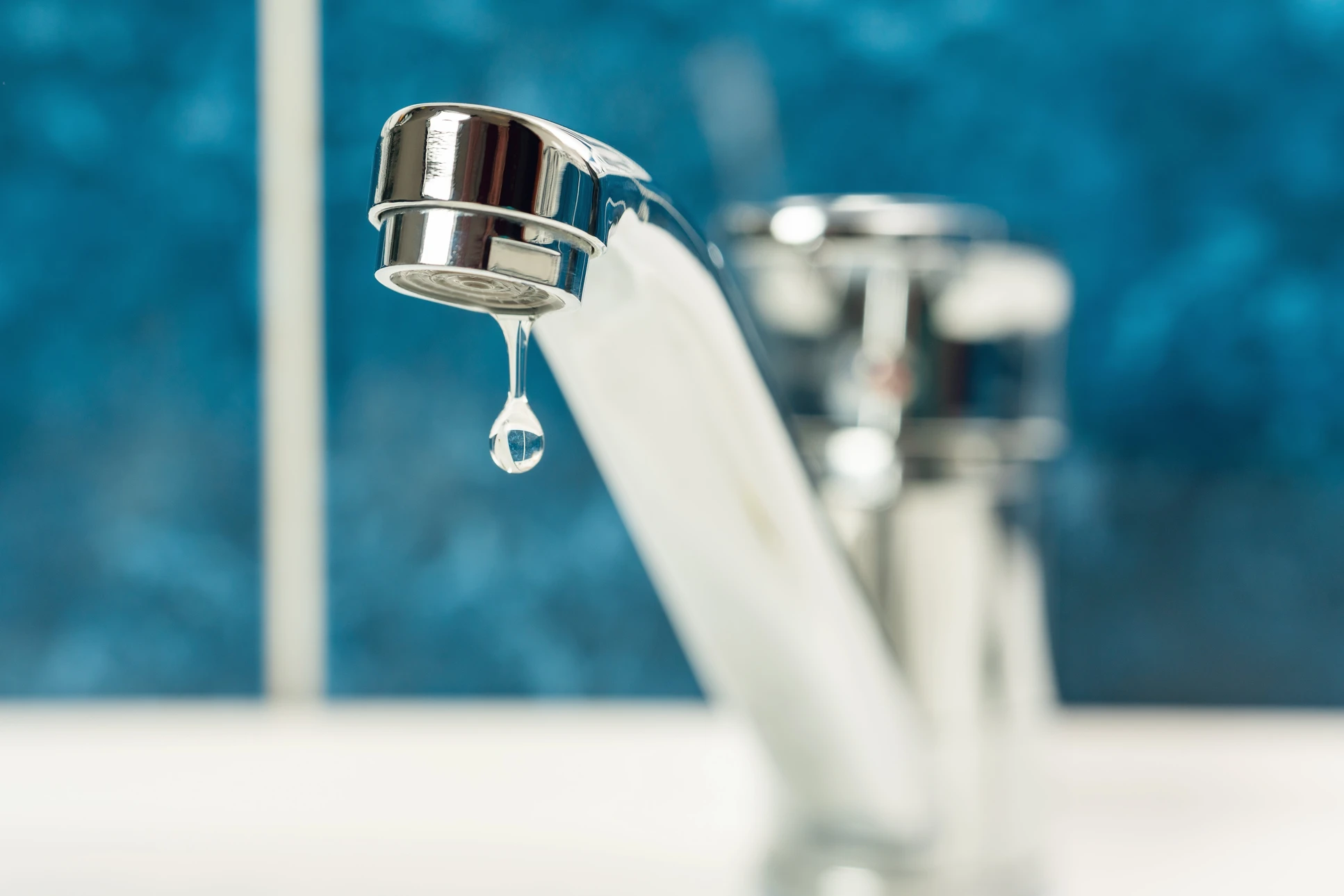 Intérieur domestique avec robinet de cuisine ou salle de bain en chrome présentant une fuite d'eau