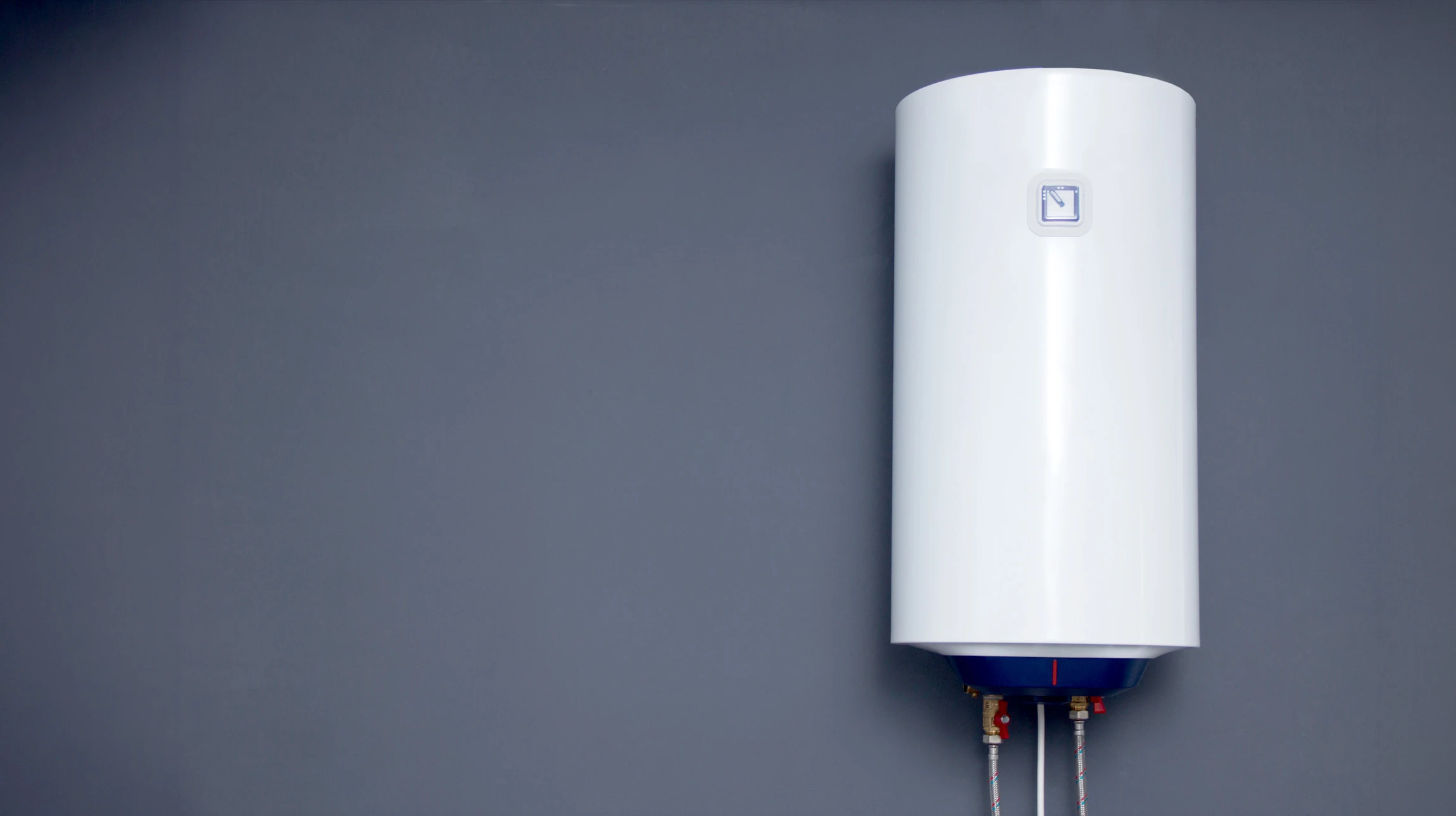 Plombier professionnel effectuant la maintenance d'un chauffe-eau électrique dans un sous-sol résidentiel
